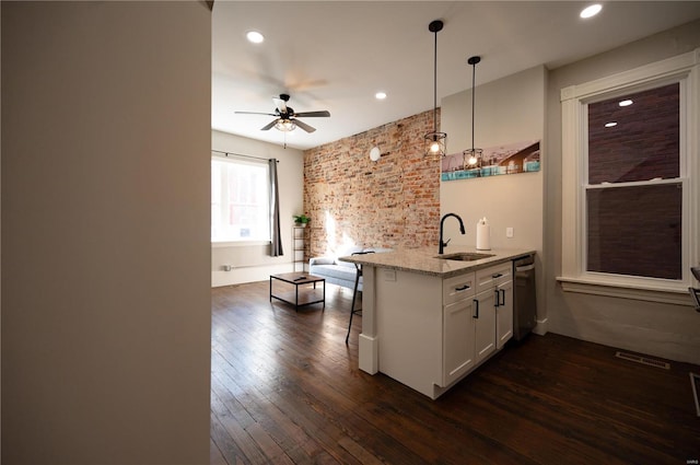 kitchen featuring light stone countertops, sink, ceiling fan, decorative light fixtures, and white cabinets