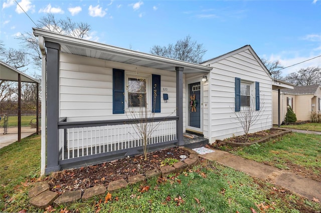 view of front of home featuring covered porch and a front lawn