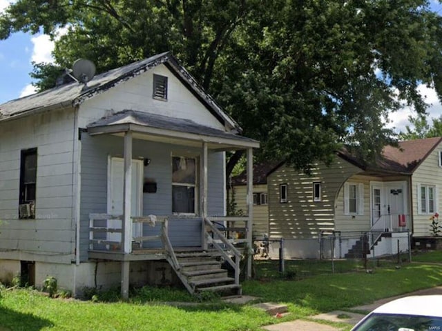 bungalow-style home featuring a front lawn and covered porch