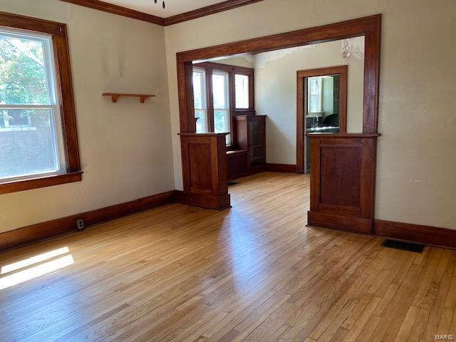 spare room featuring light hardwood / wood-style flooring and crown molding