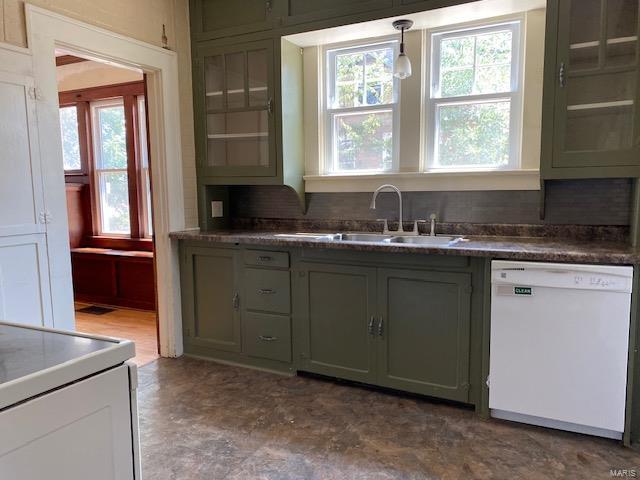 kitchen with white dishwasher, sink, hanging light fixtures, and a wealth of natural light