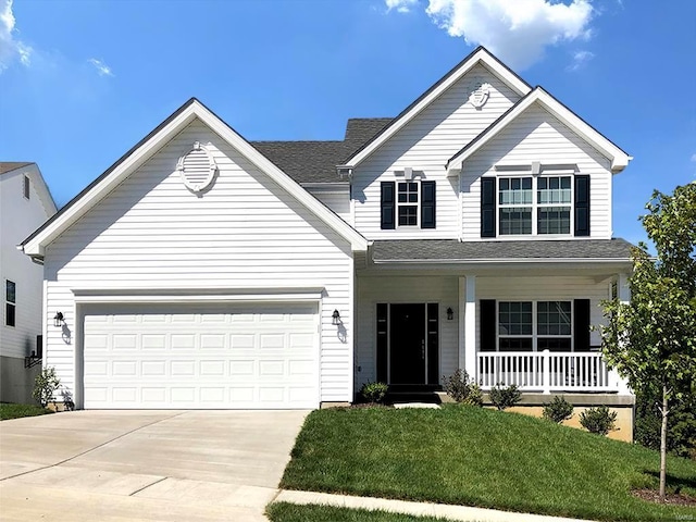 view of front property with a garage, covered porch, and a front lawn