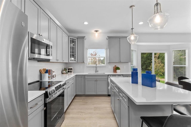 kitchen featuring hanging light fixtures, stainless steel appliances, a wealth of natural light, and sink