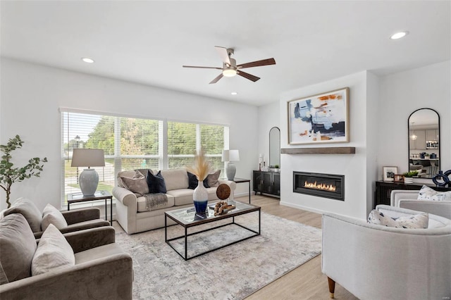 living room featuring ceiling fan and light hardwood / wood-style floors