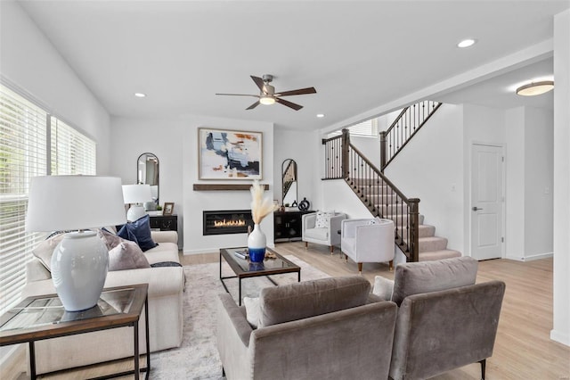 living room featuring ceiling fan and light hardwood / wood-style floors