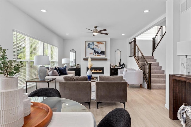 living room with ceiling fan and light hardwood / wood-style flooring