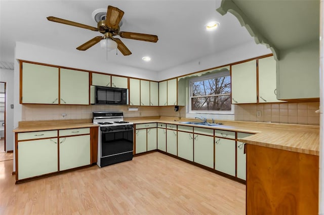 kitchen featuring backsplash, sink, ceiling fan, light wood-type flooring, and range with gas cooktop