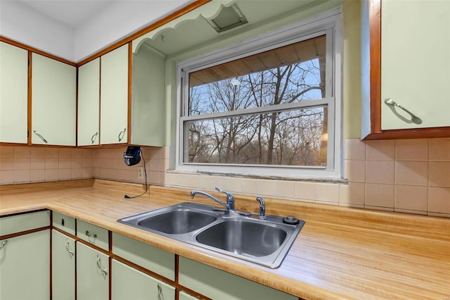 kitchen featuring white cabinets, decorative backsplash, and sink