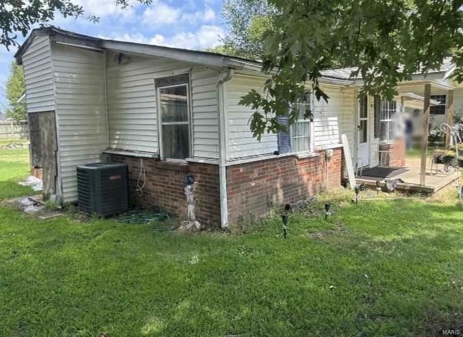 view of property exterior featuring a yard and central AC