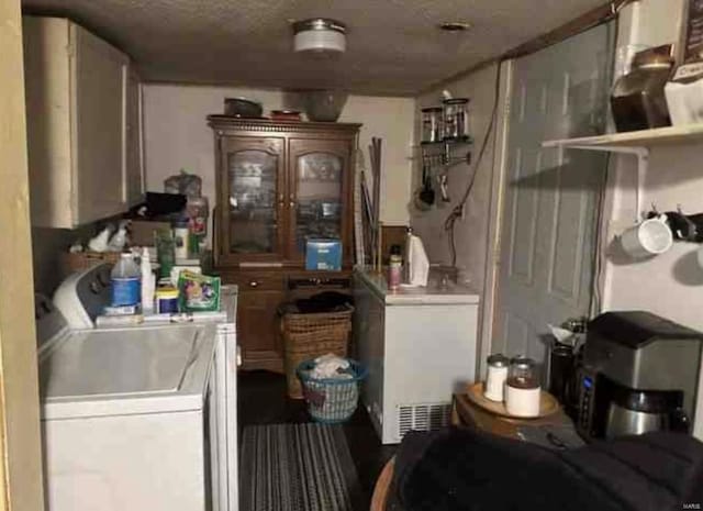 laundry area with a textured ceiling and washing machine and clothes dryer