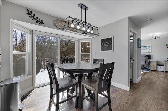 dining area with baseboards and wood finished floors