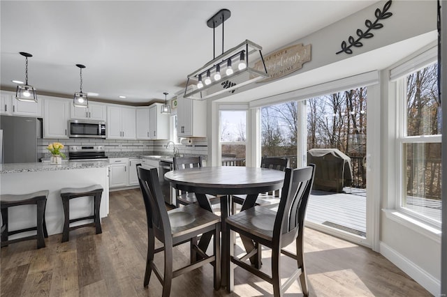 dining area with dark wood-type flooring and baseboards