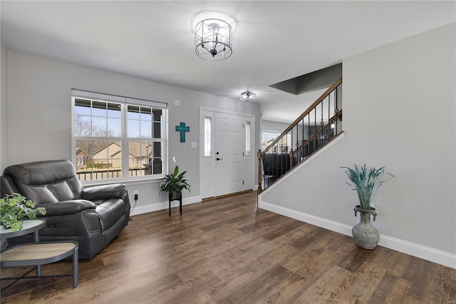 foyer featuring wood finished floors, baseboards, and stairs