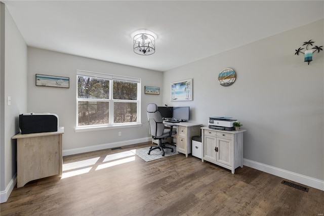 office featuring visible vents, baseboards, and wood finished floors