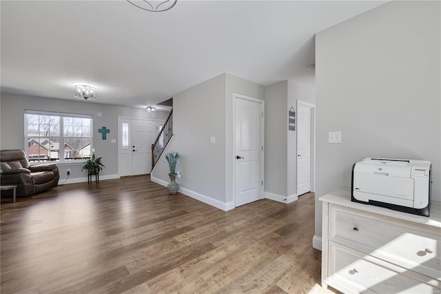 foyer featuring stairs, light wood-type flooring, and baseboards