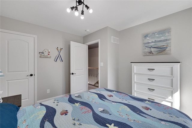 bedroom with baseboards, visible vents, and a notable chandelier