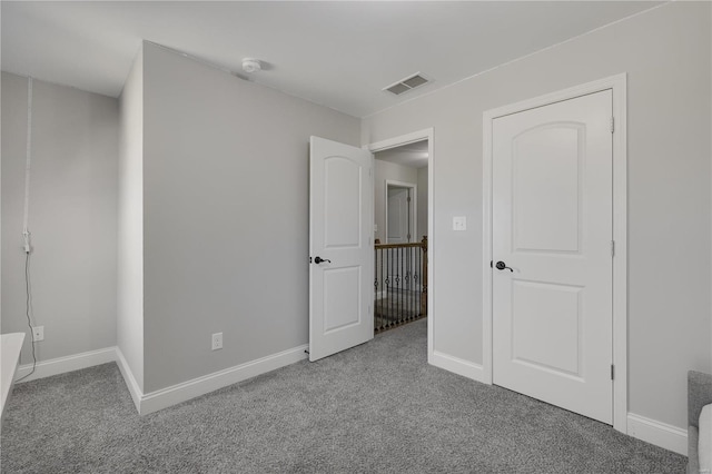 unfurnished bedroom with baseboards, visible vents, and carpet flooring