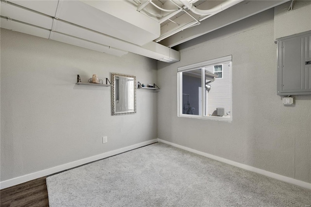 empty room with electric panel and baseboards