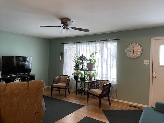 living room featuring ceiling fan and hardwood / wood-style flooring