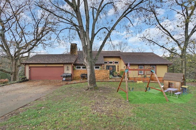 view of front facade with a playground, a garage, and a front lawn