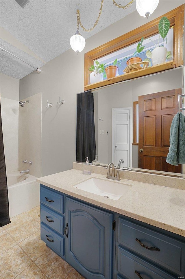 bathroom featuring tile patterned flooring, vanity, shower / bath combination with curtain, and a textured ceiling