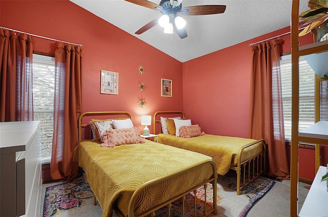 bedroom with a textured ceiling, ceiling fan, carpet floors, and lofted ceiling