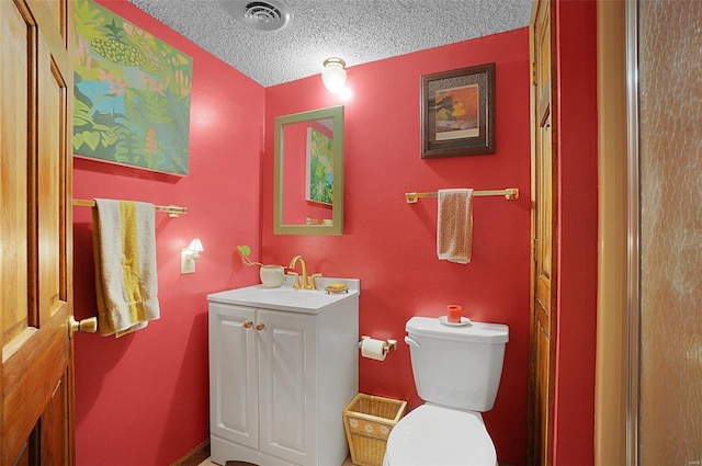 bathroom featuring vanity, a textured ceiling, and toilet