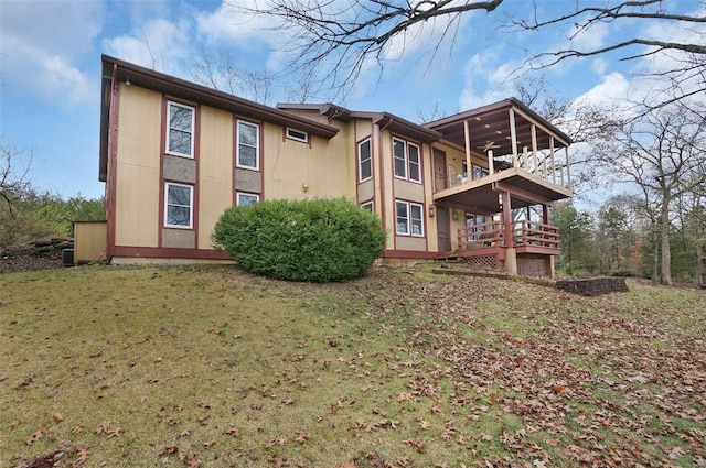 back of property featuring a balcony and a lawn