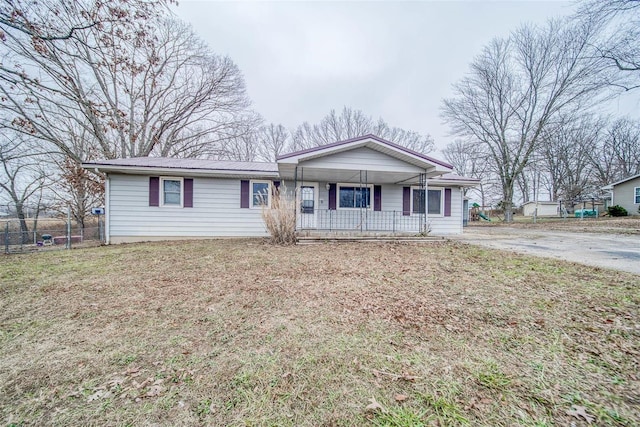 single story home featuring covered porch and a front yard