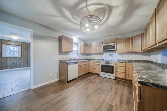 kitchen featuring sink, stainless steel appliances, dark hardwood / wood-style floors, a textured ceiling, and decorative backsplash