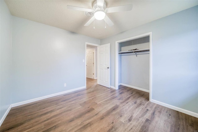 unfurnished bedroom featuring hardwood / wood-style flooring, ceiling fan, and a closet