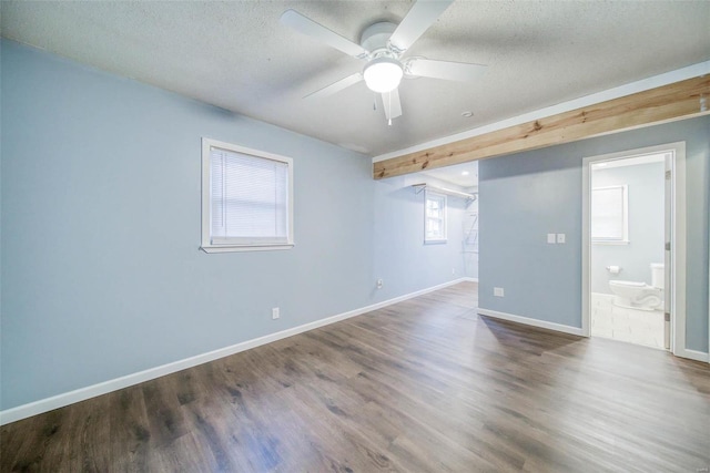 empty room with ceiling fan, wood-type flooring, and a textured ceiling