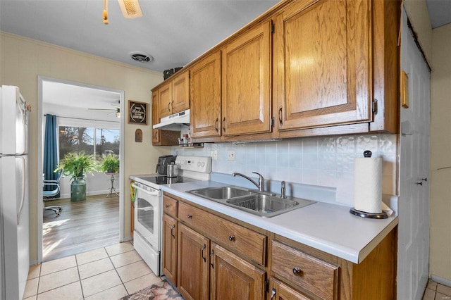 kitchen with backsplash, white appliances, ceiling fan, sink, and light hardwood / wood-style flooring