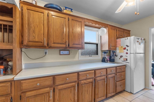 kitchen with ceiling fan, crown molding, light tile patterned floors, and white refrigerator