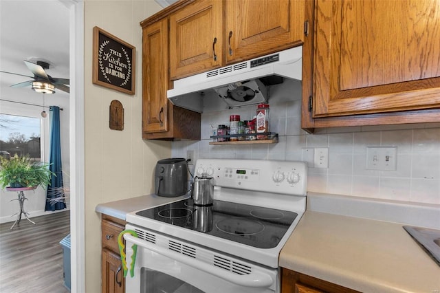 kitchen featuring tasteful backsplash, electric range, ceiling fan, and wood-type flooring