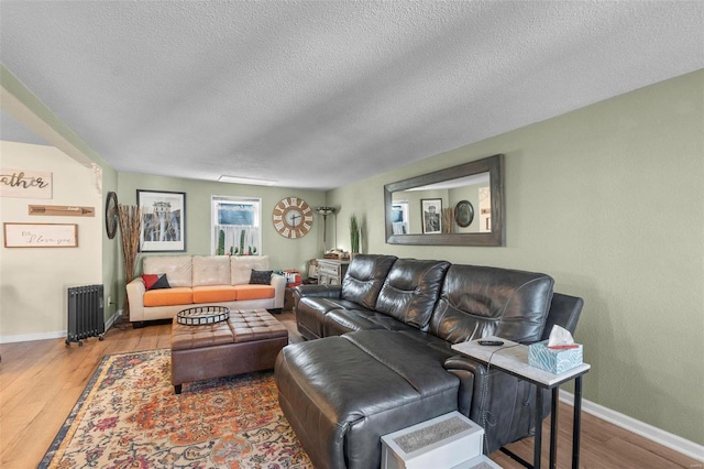 living room featuring a textured ceiling, hardwood / wood-style flooring, and radiator