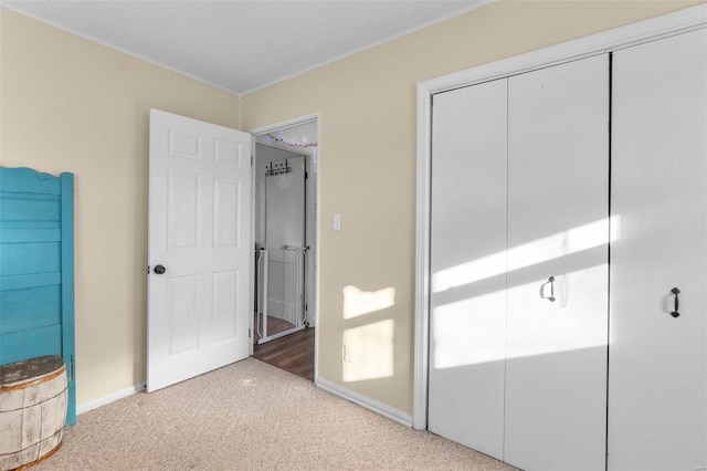 unfurnished bedroom with light colored carpet and a closet