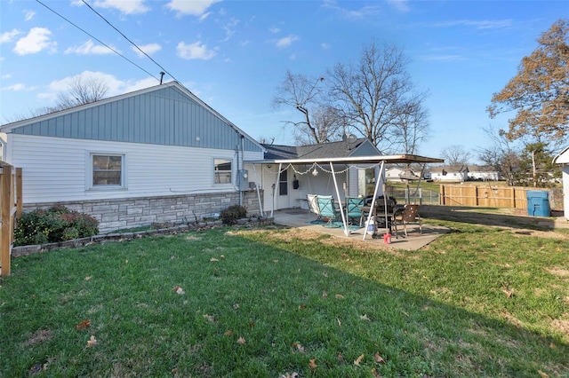 rear view of property with a lawn and a patio