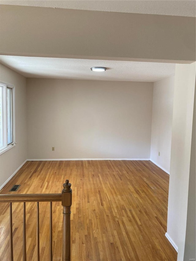 spare room featuring hardwood / wood-style flooring and a textured ceiling