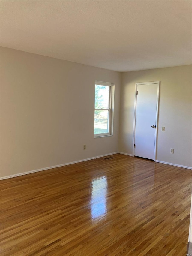 spare room with hardwood / wood-style floors