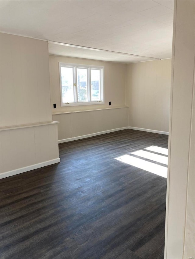 spare room with dark wood-type flooring