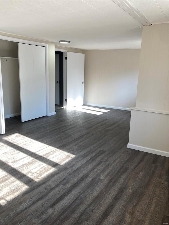 unfurnished bedroom with a closet and dark hardwood / wood-style flooring