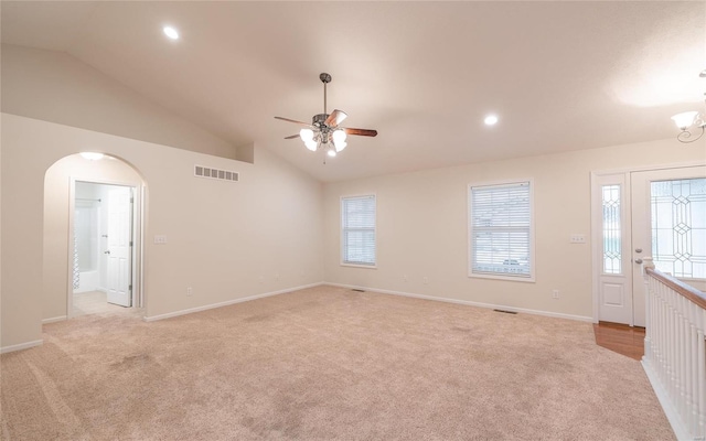 interior space with light carpet, ceiling fan with notable chandelier, and high vaulted ceiling