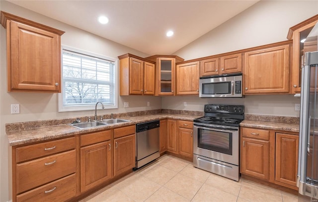 kitchen with sink, vaulted ceiling, and appliances with stainless steel finishes