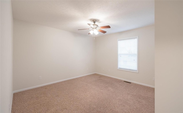 carpeted empty room featuring a textured ceiling and ceiling fan