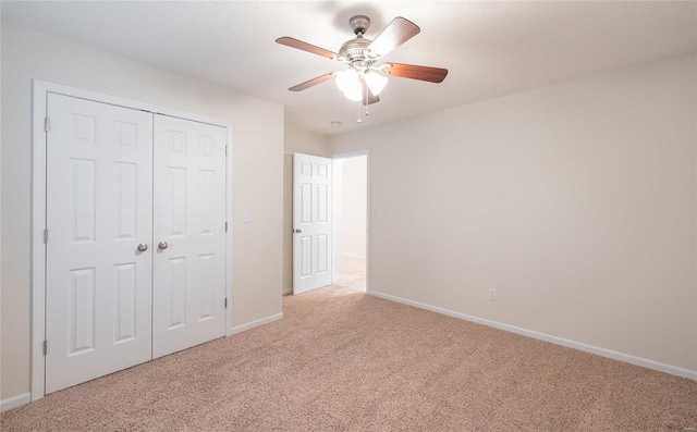 unfurnished bedroom with light carpet, a closet, and ceiling fan