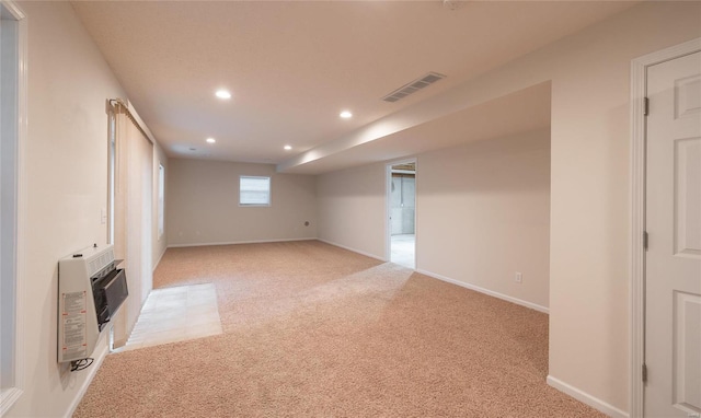 basement featuring heating unit and light carpet