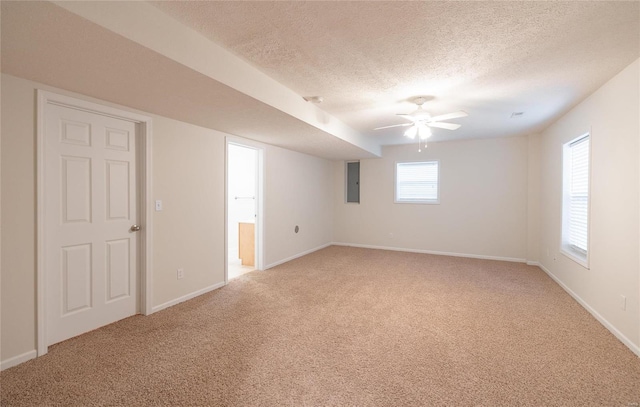 empty room featuring electric panel, ceiling fan, light colored carpet, and a textured ceiling