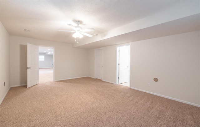 carpeted spare room featuring ceiling fan and a textured ceiling