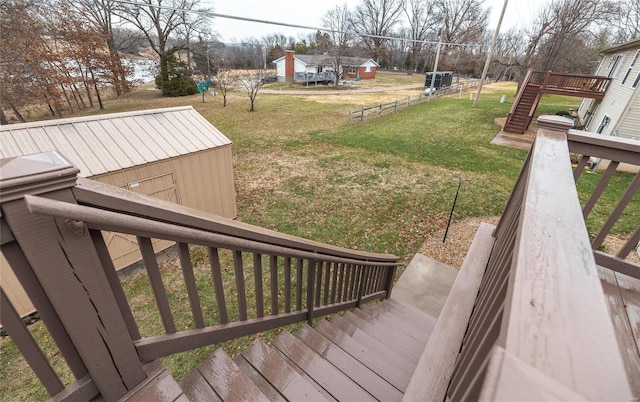 wooden deck featuring a yard and a storage shed